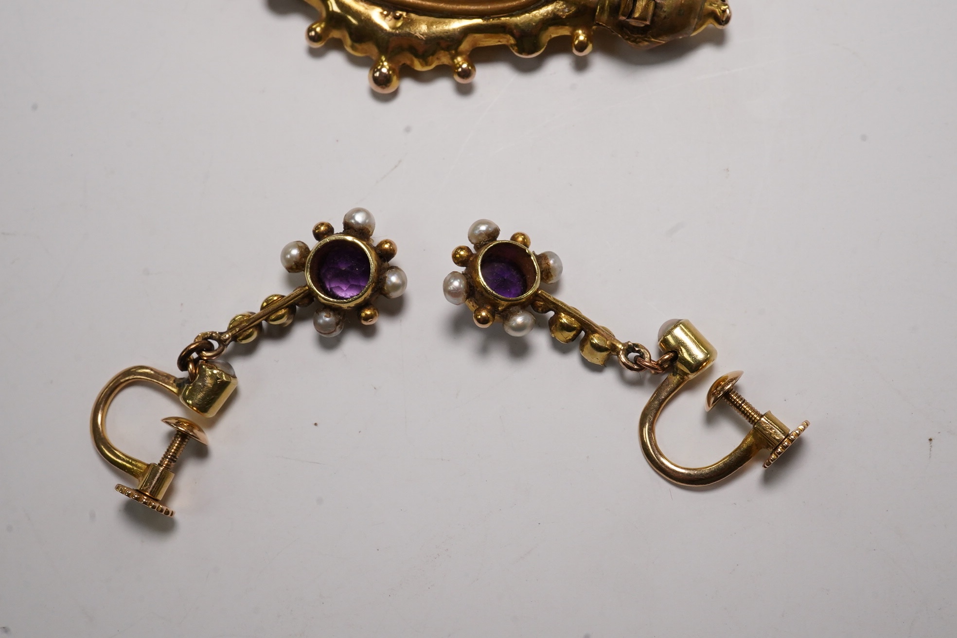 A pair of antique yellow metal, amethysts and seed pearl set drop earrings, 22mm and a Victorian 9ct, ruby and split pearl set brooch, gross weight 6.6 grams. Condition - fair to good